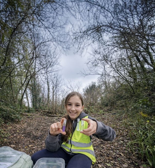 Community volunteers collecting water samples for freshwater pollution monitoring